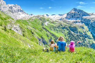 Fototapeta na wymiar young people sitting on a meadow surrounded by Swiss nature and mountain scenery