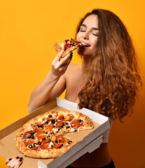 Young beautiful woman eat pepperoni pizza slice and hold whole pizza in box