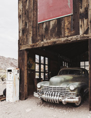Old vintage rusty car truck abandoned in the abandoned gas station.
