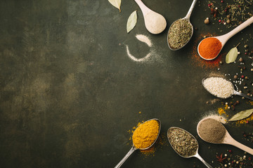 Spices and herbs over black stone background. Top view. Copy space