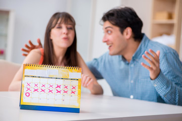 Fototapeta premium Young family in pregnancy planning concept with ovulation calend