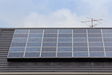 solar panel on house roof against blue sky with cloud