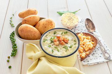 Homemade cream of potato soup with croutons, served with bread toasted with cheese