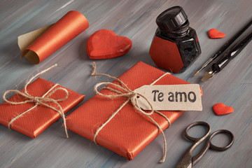 Packed presents, cord, a pen, poster dip nib and ink well. Text "Te amo" on the lable