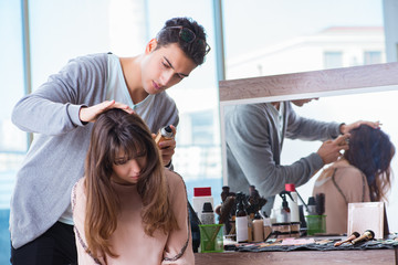 Obraz na płótnie Canvas Man stylist working with woman in beauty salon