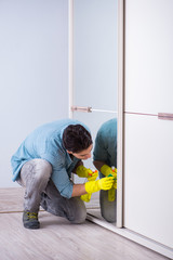 Young man cleaning mirror at home hotel