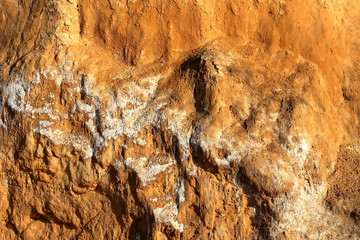 Detail of natural orange brown loamy (clay) soil of ravine wall with rough texture background