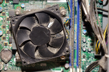 Dust on computer PC CPU cooler with motherboard and a fragment of the computer case.