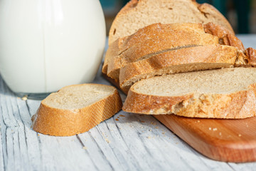 Still life with slices of bread and milk on a wooden background