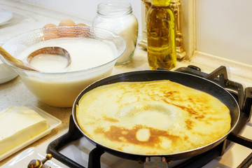 The process of making pancakes in the background milk, eggs, sugar, salt, flour, vegetable oil.