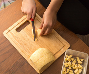 Slicing cheese with a knife on the board