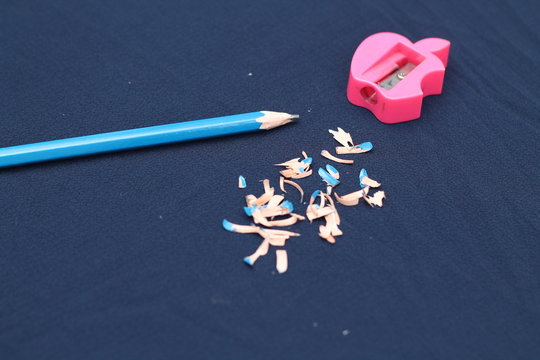 pencil and sharpener above the blue background.