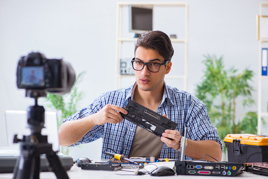 Vlogger recording computer repair on camera for vlog blog