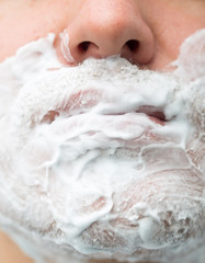 A man is applying face shaving foam