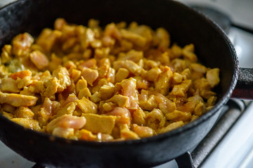 small chicken pieces are fried in a frying pan