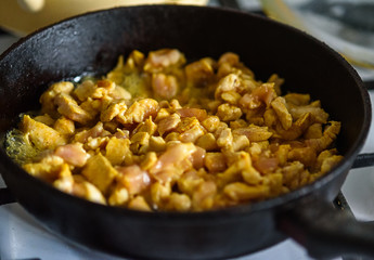 small chicken pieces are fried in a frying pan