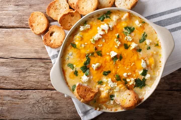  American food: hot chicken buffalo dip close-up in a baking dish with toasted bread. Horizontal top view © FomaA