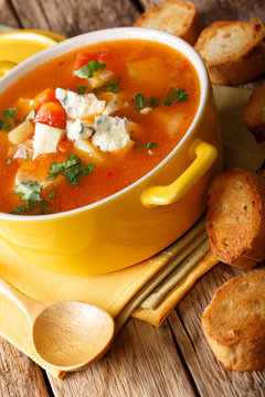 Delicious chicken buffalo soup with tomatoes, celery, carrots and blue cheese close-up in a saucepan. vertical
