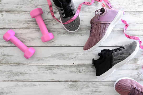 Womens sport footwear (sneakers) and  equipment (pink dumbbells, tape measure). Active lifestyle concept, Flat lay