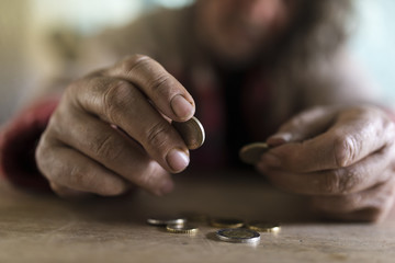 Senior man with dirty hands counting coins