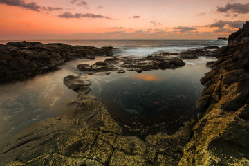 Long Exposure sunrise, colorful sky, volcanic rock beautiful seascape at Gran Canaria Island Coast in Spain.