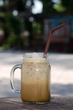 Iced coffee in glass on wooden
