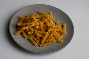 Heap of fusilli pasta isolated on grey concrete plate