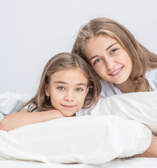 Mother with daughter lie on the bed together