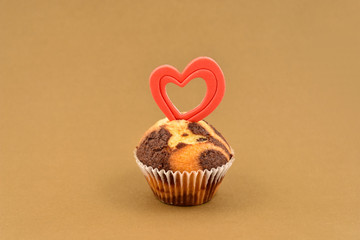 Muffin with heart stock images. Chocolate muffin with heart on a brown background. Sweet valentine pastry. Valentines Day concept