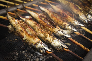 Barbecue with fish. Grilled fish (mackerel) on a stick