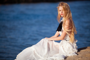 Fototapeta na wymiar bride in long white dress by the sea
