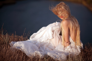 bride in long white dress by the sea