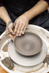 Artist makes clay pottery on a spin wheel