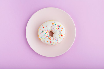 donut on a pink plate on a purple background  close-up ,top view