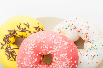a bunch of donuts on a plate and on a white background close-up