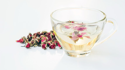 A cup of tea pink rose on a white background.