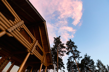 Modern russian village in national russian style on the lake coast. Good place for camping, fishing, hunting and relax. Summer sunset sky reflection in calm warm water.