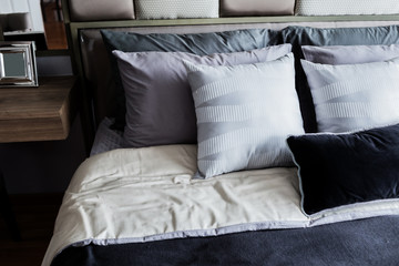 Bed maid-up with clean white  pattern pillows and bed sheets in beauty room. Close-up. Lens flair in sunlight.