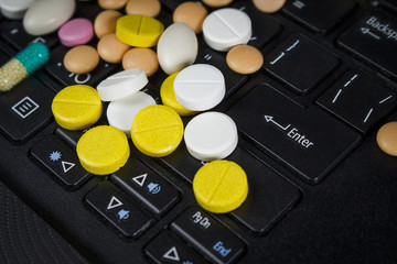 A pile of pills on the laptop keyboard