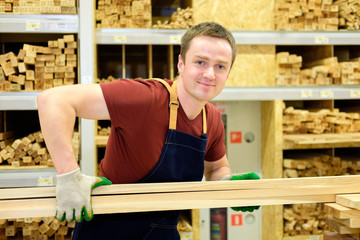 worker or seller in construction store or warehouse wood section at work