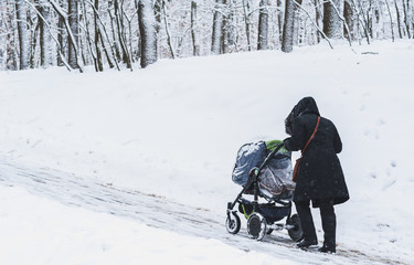 Fototapeta na wymiar A woman with a stroller in winter