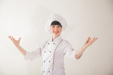 Young girl in the clothes of the cook. Confectioner on a white background.