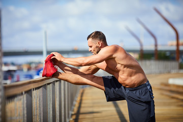man stretching before and outdoors workout