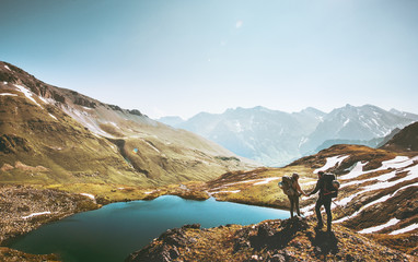 Couple travelers holding hands on mountain cliff over lake together love and Travel Lifestyle wanderlust concept adventure vacations outdoor aerial view. - Powered by Adobe