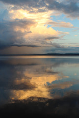 Fototapeta na wymiar Sunset and clouds reflected in Orsa lake.
