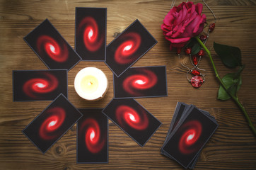 Tarot cards and rose flower on fortune teller desk table background. Future reading. Love or...