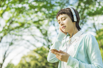 公園で音楽を聴く女性