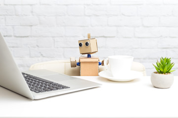 The robot works behind a laptop and drinks coffee. Artificial Intelligence