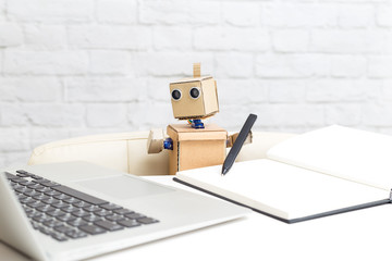 The robot looks at the laptop screen and writes with a pen. Artificial Intelligence