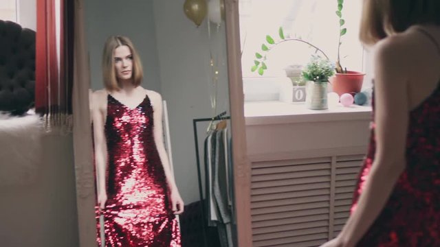 Sexy young woman trying on red sequin dress
